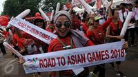 Peserta Parade Asean Games 2018 Jakarta - Palembang membawa baner bertuliskan "Road To Asian Games 2018, Jakarta, Minggu (27/12/2015). Indonesia akan menjadi tuan rumah perhelatan Asian Games 2018 mendatang. (Liputan6.com/Johan Tallo)