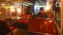 Pengunjung menyantap makanan di kafe yang menggunakan angkutan metromini di Bekasi, Jawa Barat, Kamis (15/4/2021). Kafe ini berinovasi di tengah pandemi COVID-19 dengan menggunakan armada metromini yang sudah tidak terpakai sebagai tempat makan pengunjung. (Liputan6.com/Herman Zakharia)