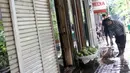 Pedagang buah menyapu sekitar lokasi tempat berdagang di depan pertokoan Pasar Baru, Jakarta, Kamis (2/1/2020). Pasca banjir yang melanda sejumlah titik di Jakarta pada Rabu (1/1), aktivitas perniagaan di kawasan Pasar Baru masih sepi dan sebagian toko masih tutup. (Liputan6.com/Helmi Fithriansyah)