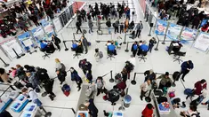 Wisatawan mengantre untuk melewati pos pemeriksaan keamanan di Bandara Internasional John F. Kennedy, New York, Rabu (21/11). Masyarakat Amerika mulai bergegas pulang ke kampung halamannya alias mudik untuk merayakan Thanksgiving Day. (AP/Mark Lennihan)