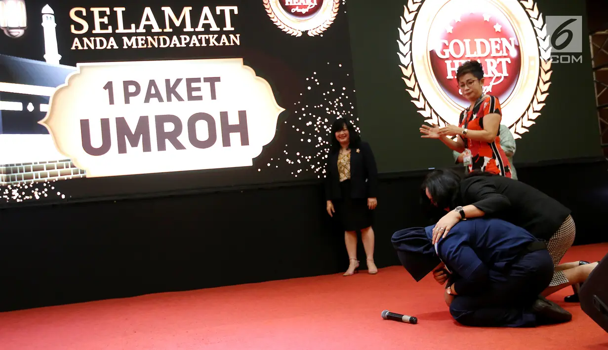 Karyawan Susanti sujud syukur menerima apresiasi berupa paket umroh pada acara Golden Heart Award di Lippo Mall Puri, Jakarta, Rabu (13/3). Program apresiasi ini diharapkan dapat lebih meningkatkan kejujuran. (Liputan6.com/Fery Pradolo)