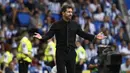 Pelatih Atletico Madrid, Diego Simeone melakukan protes kepada wasit saat timnya bertamu ke kandang Real Sociedad. Ia pun harus diganjar kartu kuning atas perbuatannya pada injury time babak pertama. (AFP/Pierre-Philippe Marcou)