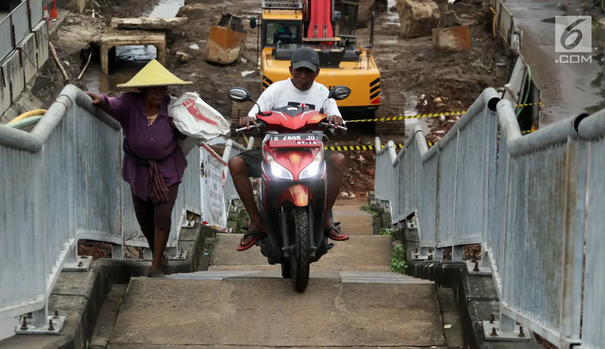 Pengendara motor melintas di samping pejalan kaki menaiki Jembatan Penyeberangan Orang kawasan Cikunir, Bekasi Barat, Senin (12/3). JPO yang diperuntukkan bagi pejalan kaki ini justru digunakan pemotor mencari jalan pintas. (Liputan6.com/Arya Manggala)
