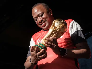 Presiden Kenya Uhuru Kenyatta memegang trofi Piala Dunia FIFA saat Tur Dunia di Gedung Negara, Nairobi (26/2). Trofi ini terbuat dari emas murni 18 karat dengan dasar perunggu, setinggi 36,8 sentimeter dan berat 6,1 kilogram. (AFP Photo/Yasuyoshi Chiba)
