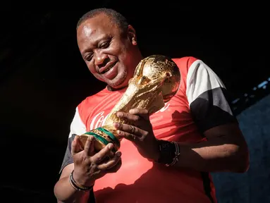 Presiden Kenya Uhuru Kenyatta memegang trofi Piala Dunia FIFA saat Tur Dunia di Gedung Negara, Nairobi (26/2). Trofi ini terbuat dari emas murni 18 karat dengan dasar perunggu, setinggi 36,8 sentimeter dan berat 6,1 kilogram. (AFP Photo/Yasuyoshi Chiba)