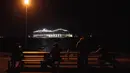 Warga menyaksikan kapal pesiar MSC World Europa meninggalkan pelabuhan Saint-Nazaire, Prancis barat pada 26 Oktober 2022.  MSC World Europa berlayar ke Qatar, di mana ia akan berfungsi sebagai hotel terapung selama Piala Dunia FIFA Qatar 2022. (AFP/Sebastien Salom Gomis)