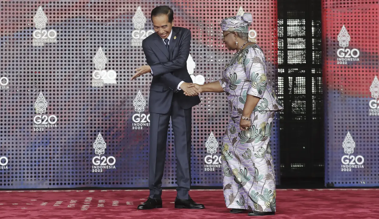 Presiden Indonesia Joko Widodo atau Jokowi menyapa Direktur Jenderal Organisasi Perdagangan Dunia (WTO) Ngozi Okonjo-Iweala saat tiba pada hari pertama Konferensi Tingkat Tinggi (KTT) G20 di Nusa Dua, Bali, Selasa (15/11/2022) pagi. Jokowi menyampaikan ucapan selamat datang di lobi depan venue utama KTT G20. (Mast Irham/Pool Photo via AP)