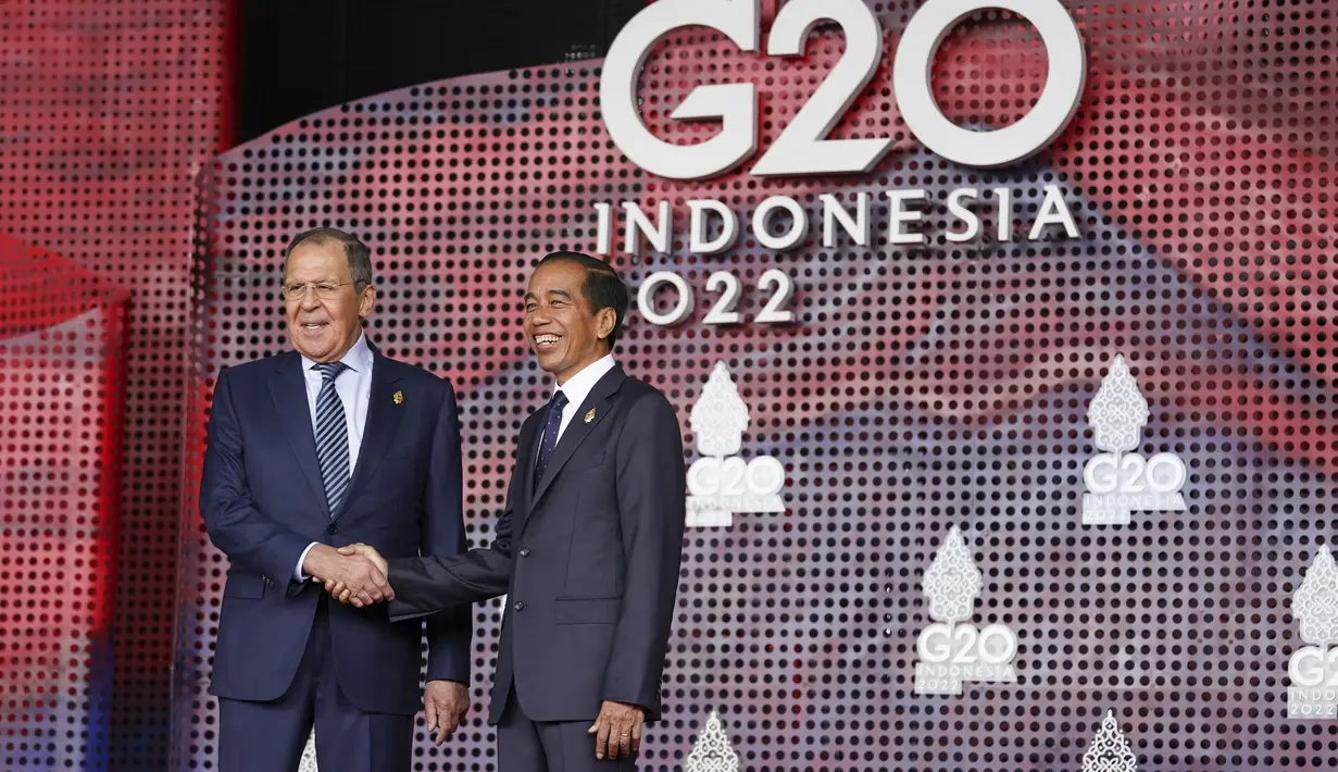 Menteri Luar Negeri Rusia Sergei Lavrov menyapa Presiden Indonesia Joko atau Jokowi yang menyambutnya pada hari pertama Konferensi Tingkat Tinggi (KTT) G20 di Nusa Dua, Bali, Selasa (15/11/2022) pagi. Setidaknya total 17 kepala negara G20 akan menghadiri KTT dua hari ini. (Kevin Lamarque/Pool via AP)