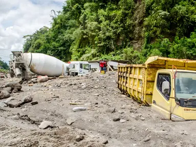 Truk milik penambang pasir tertimbun abu vulkanik setelah hujan deras mengguyur lereng Gunung Merapi di Magelang, 2 Desember 2021. Sejumlah truk tambang tertimbun lahar dingin Gunung Merapi. (AGUNG SUPRIYANTO/AFP)