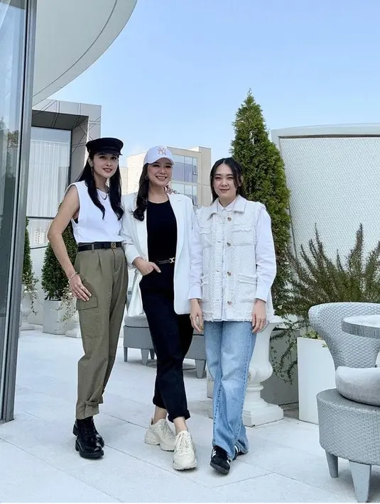 Sandra Dewi dan kedua sahabatnya pun kembali serasi mengenakan atasan warna putih. Sandra mengenakan atasan putih tanpa lengan dipadukan celana hijau army dan boots hitam [@sandradewi88]