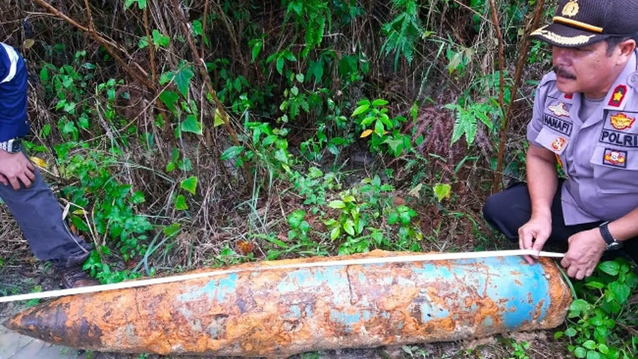 Kapolsek Tenayan Raya Pekanbaru Kompol Hanafi mengukur benda yang diduga bom di lokasi penggalian pipa.