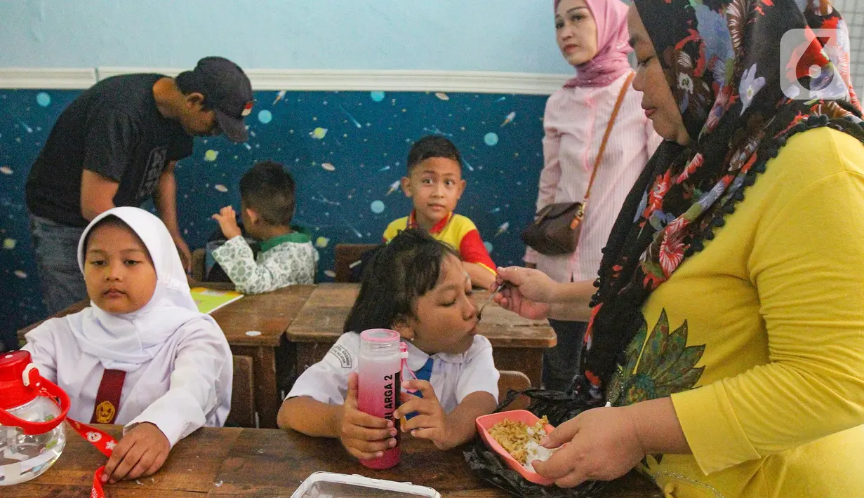 Para orang tua siswa tampak mengantar dan menemani anak mereka pada hari pertama sekolah. (merdeka.com/Arie Basuki)