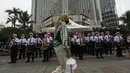 Seorang wanita berjalan di depan para peserta yang sedang bermain angklung saat acara Christmas in Jakarta di Bundaran Hotel Indonesia, Jakarta, Selasa (21/12/2021). Pemerintah Provinsi DKI Jakarta menggelar Christmas in Jakarta dalam rangka menyambut Natal 2021. (Liputan6.com/Johan Tallo)