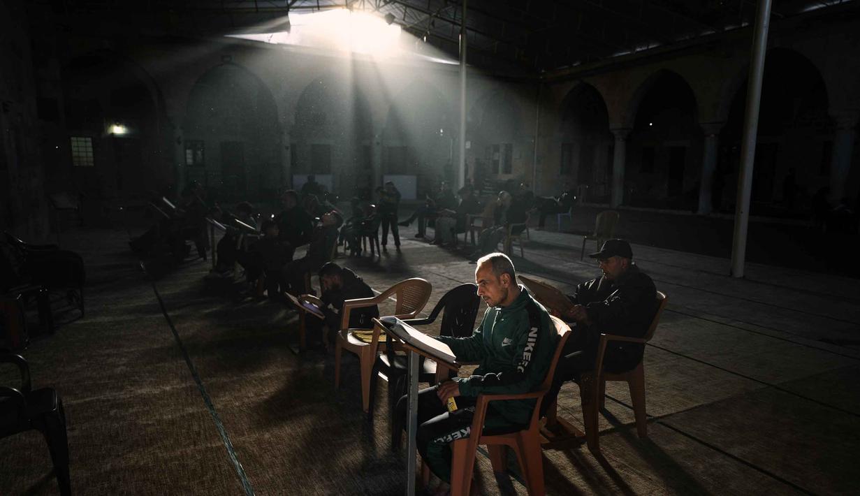 Warga Palestina membaca Al-Quran selama bulan suci Ramadan di Masjid Sayed Al-Hashim, Kota Gaza, Kamis 19 Februari 2026. Ramadan 1447 Hijriah atau 2026 Masehi di Gaza berlangsung dalam kondisi yang memprihatinkan. (AP Photo/Jehad Alshrafi)