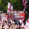 Para penggemar melambaikan tangan ke arah bus yang membawa para pemain dan staf selama perayaan kemenangan kepulangan timnas putri Inggris di The Mall di luar Istana Buckingham di London pada 29 Juli 2025 setelah tim tersebut memenangkan Euro 2025. (Adam Davy/POOL/AFP)