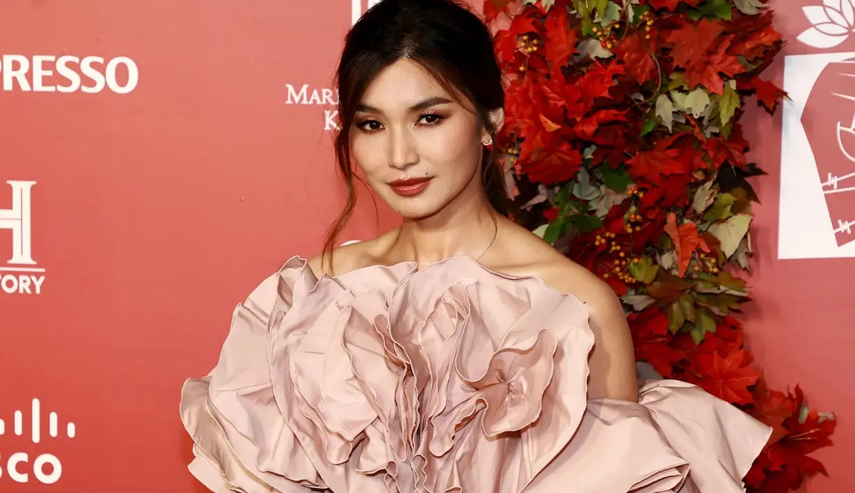 Gemma Chan dengan bibir berwarna merah cerah di red carpet. Foto: Vogue.