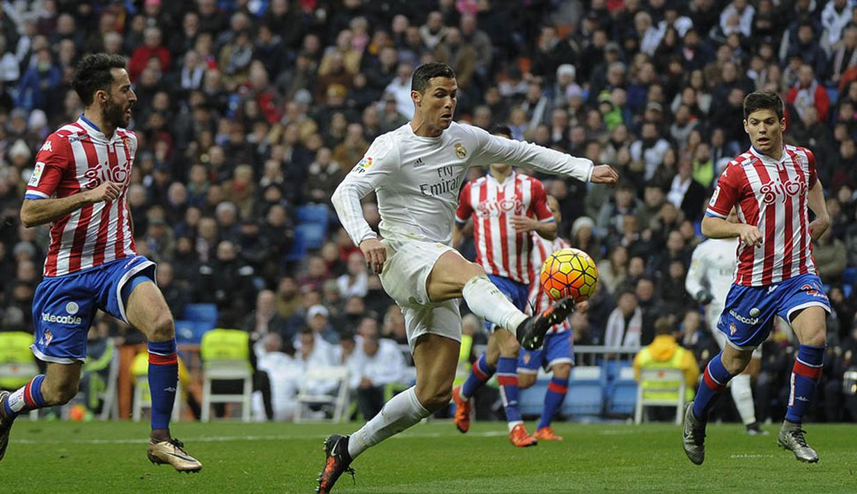 Bintang Real Madrid, Cristiano Ronaldo, mengecoh sejumlah pemain Sporting Gijon. Meski menang, Madrid masih tertahan di posisi tiga klasemen Liga Spanyol. (AFP/Pedro Armestre)