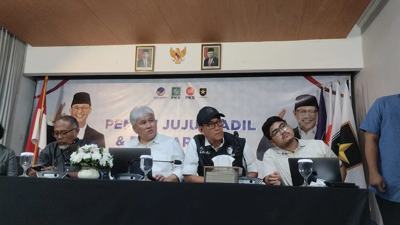 Jubir Timnas Anies-Muhaimin (AMIN) Refly Harun (rompi dan topi hitam)