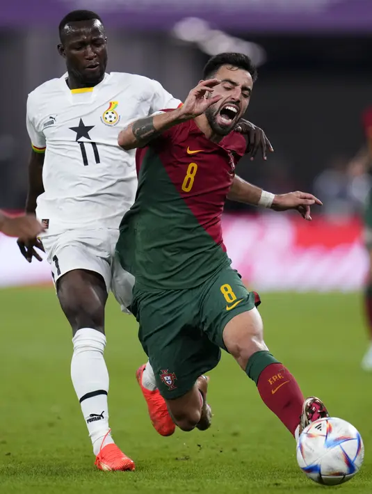 Penyerang timnas Ghana Osman Bukari berebut bola dengan gelandang Portugal Bruno Fernandes pada laga penyisihan Grup H Piala Dunia 2022 di Stadium 974, Doha, Qatar, Kamis (25/11/2022). Laga berakhir dengan skor 3-2 untuk kemenangan Portugal. (AP Photo/Manu Fernandez)
