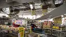 Pekerja mengeluarkan barang dagangan dari rak di bawah plafon yang rusak di sebuah supermarket di Shiroishi, prefektur Miyagi, setelah gempa magnitudo 7,3 mengguncang timur laut Jepang, Kamis (17/3/2022). Gempa pada Rabu malam ini menyebabkan dua orang meninggal dunia. (Charly TRIBALLEAU/AFP)