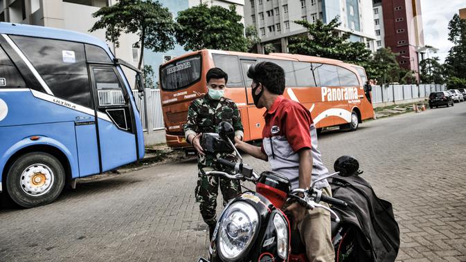 Petugas kurir JNE saat mengantarkan paket ke anggota TNI yang sedang bertugas di Wisma Atlet Pademangan, Jakarta, Selasa (29/12/2020). Beralihnya warga ke belanja melalui e-commerce karena tidak harus keluar rumah guna mencegah penularan virus corona COVID-19. (merdeka.com/Iqbal S. Nugroho)