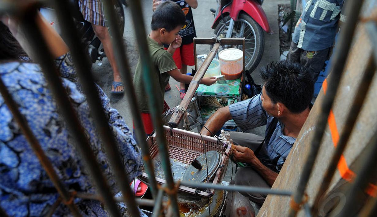 Beberapa anak kecil membeli jajanan dari seorang pedagang, Jakarta, Jumat (20/06/14). (Liputan6.com/Faisal R Syam)