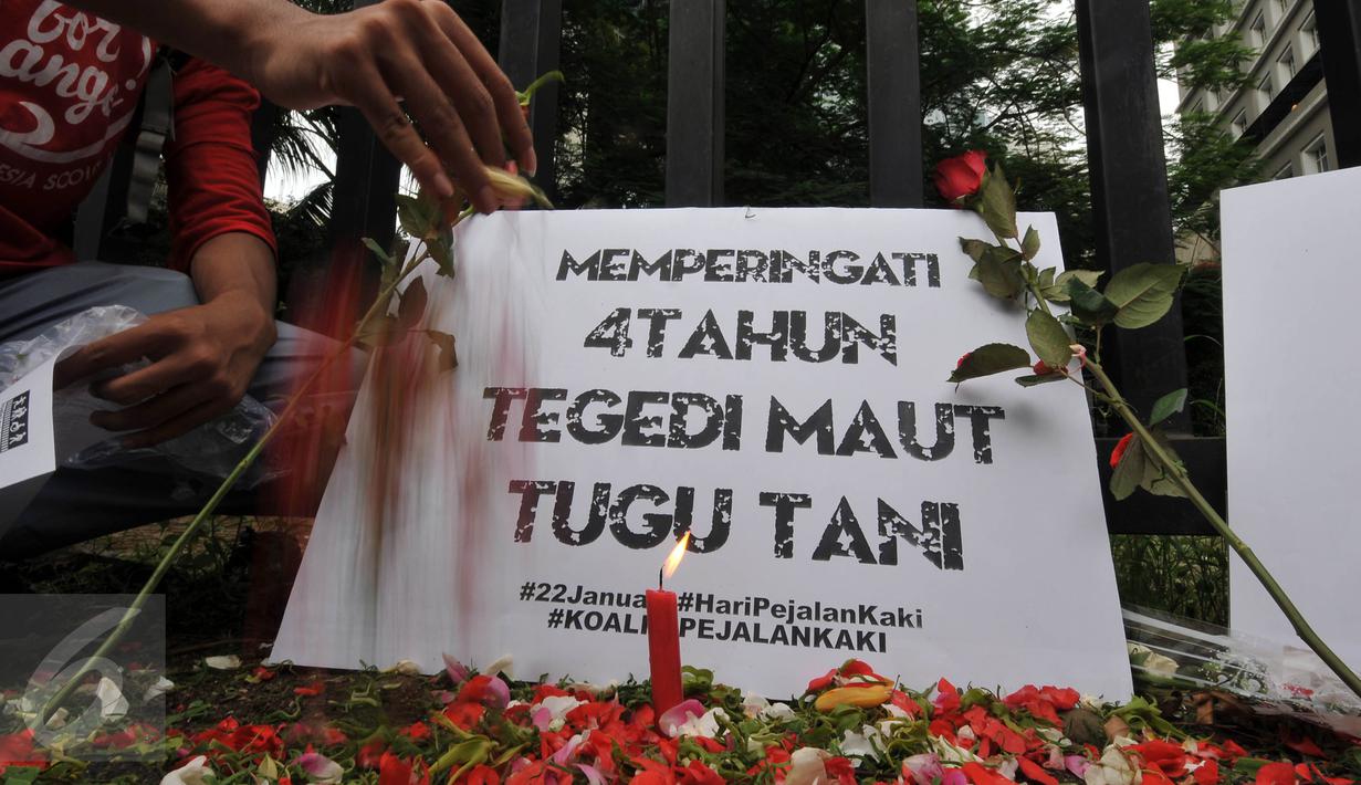 Massa yang tergabung dalam Koalisi Pejalan Kaki melakukan Aksi Doa dan Tabur Bunga di Halte Tugu Tani, Jakarta, Jumat (22/1). Aksi ini dalam rangka memperingati 4 tahun tragedi kecelakaan Tugu Tani yang menewaskan 12 orang. (Liputan6.com/Johan Tallo)