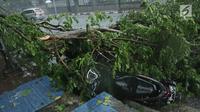 Sepeda motor tertimpa pohon tumbang di Jalan Proklamasi, Menteng, Jakarta Pusat, Minggu (31/12). Hujan deras disertai angin kencang melanda Jakarta jelang malam pergantian tahun hingga membuat beberapa pohon bertumbangan. (Liputan6.com/Herman Zakharia)