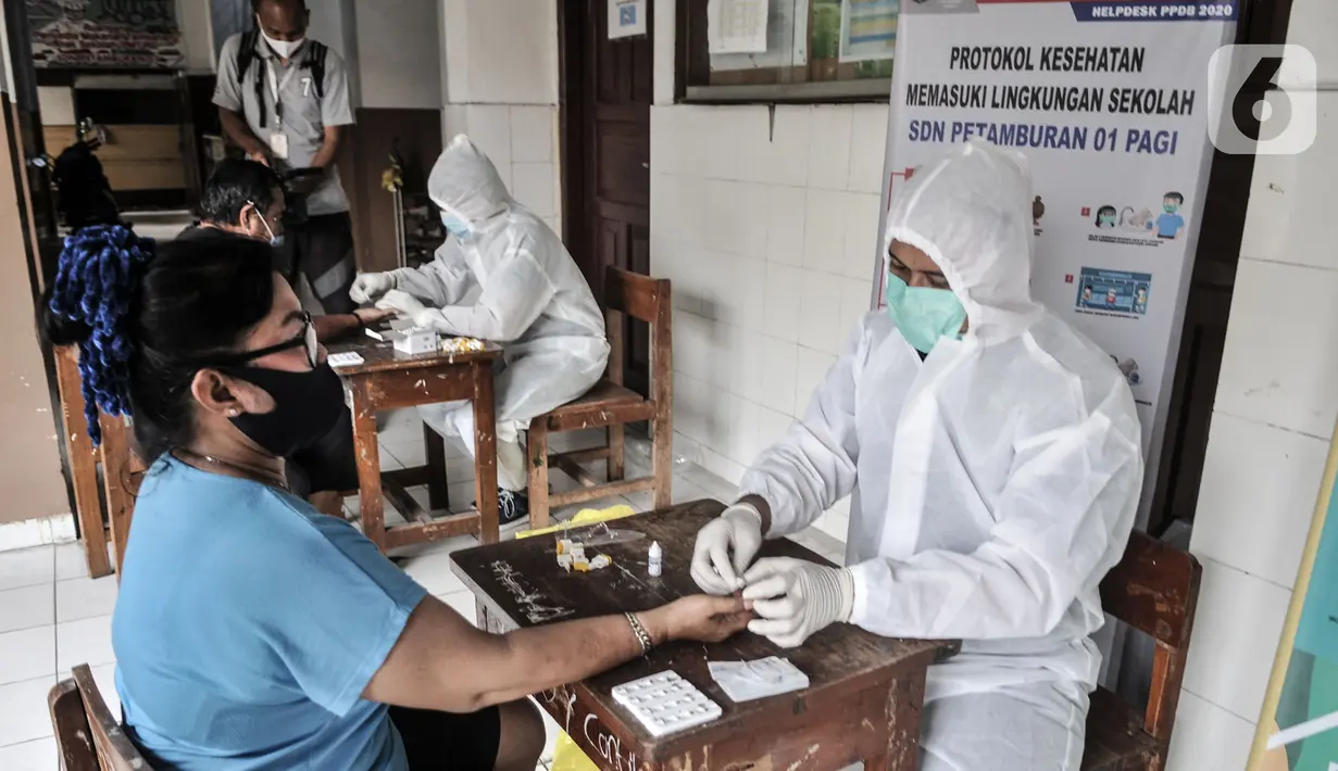 Tim medis dari Polda Metro Jaya saat menggelar rapid test kepada warga di SDN 01 Petamburan, Jakarta, Minggu (22/11/2020). Polda Metro Jaya menggelar rapid test gratis kepada warga Petamburan sebagai langkah mencegah penyebaran Covid-19. (merdeka.com/Iqbal S. Nugroho)