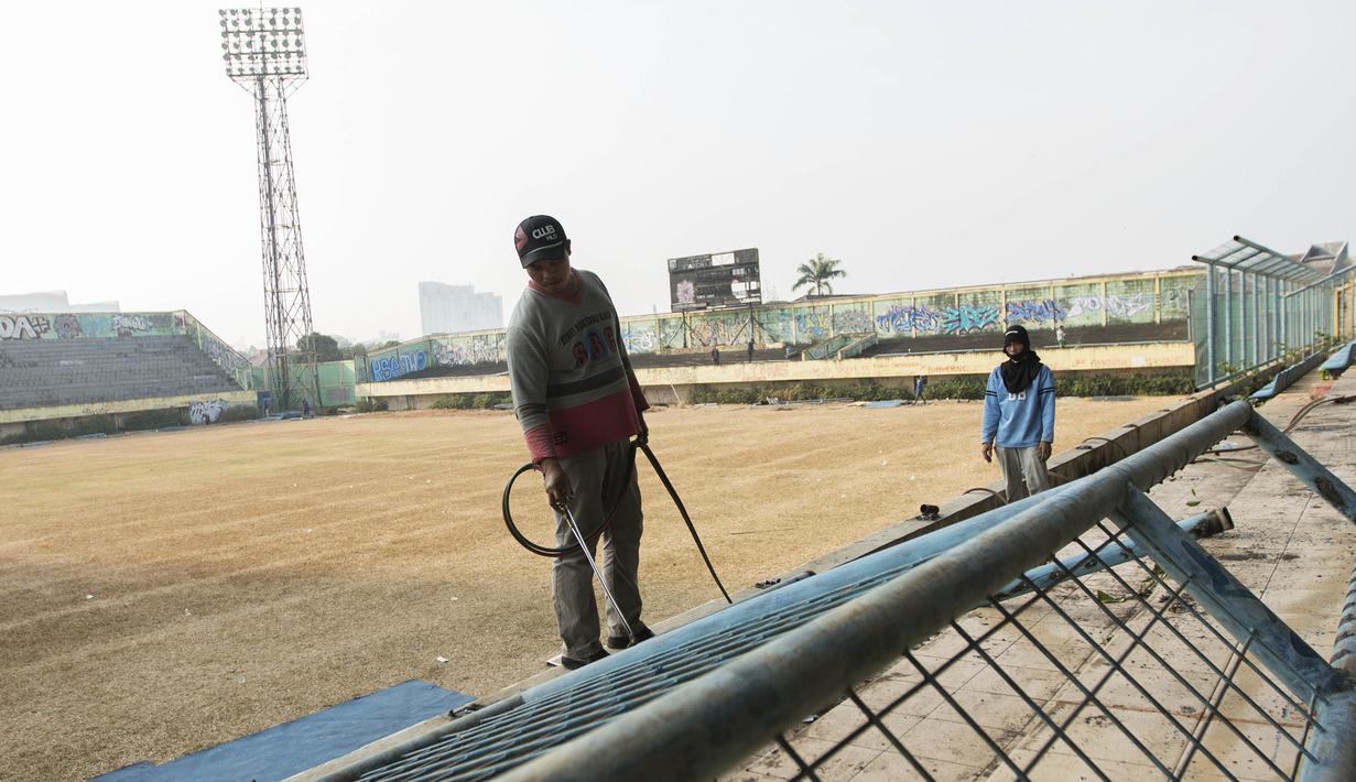 Pekerja membongkar pagar pembatas Stadion Lebak Bulus, Jumat (24/7/2015). (Bola.com/Vitalis Yogi Trisna)