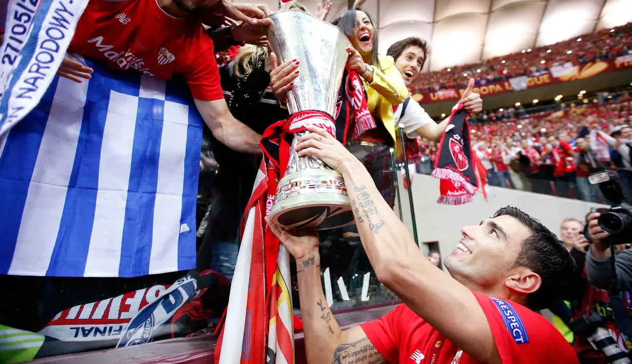 Jose Antonio Reyes memamerkan trofi juara Liga Europa 2015 ke para pendukung setia Sevilla di Stadion Narodowy, Polandia, Kamis (28/5/2015). Sevilla memecahkan rekor meraih trofi Liga Europa terbanyak, yakni empat gelar. (Reuters/Carl Recine)