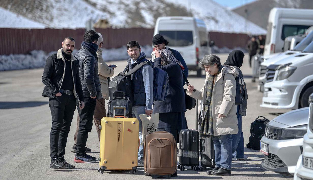 Mengantisipasi potensi gelombang pengungsi besar-besaran, pemerintah Turki memperkuat keamanan perbatasan dan mempertimbangkan pembentukan zona penyangga. Tampak dalam foto, warga negara Iran menunggu bus di Turki setelah melewati perbatasan Kapikoy/Razi di Provinsi Van, Turki timur laut, pada Selasa 3 Maret 2026, sehari setelah kedua negara tersebut secara bersama-sama menangguhkan penyeberangan harian di perbatasan mereka karena serangan Israel-Amerika Serikat yang terus menghantam wilayah Republik Islam tersebut. (Ali IHSAN OZTURK/AFP)