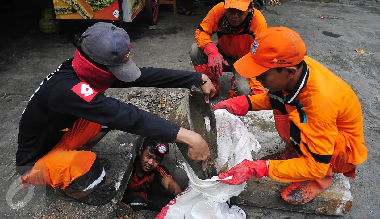 Petugas melakukan pembersihan saluran air di pinggir jalan Ampera Raya, Jakarta, Selasa (3/11/2015). Pemerintah Provinsi DKI Jakarta gencar membongkar saluran air yang tertutup beton untuk menghadapi musim penghujan. (Liputan6.com/Yoppy Renato)