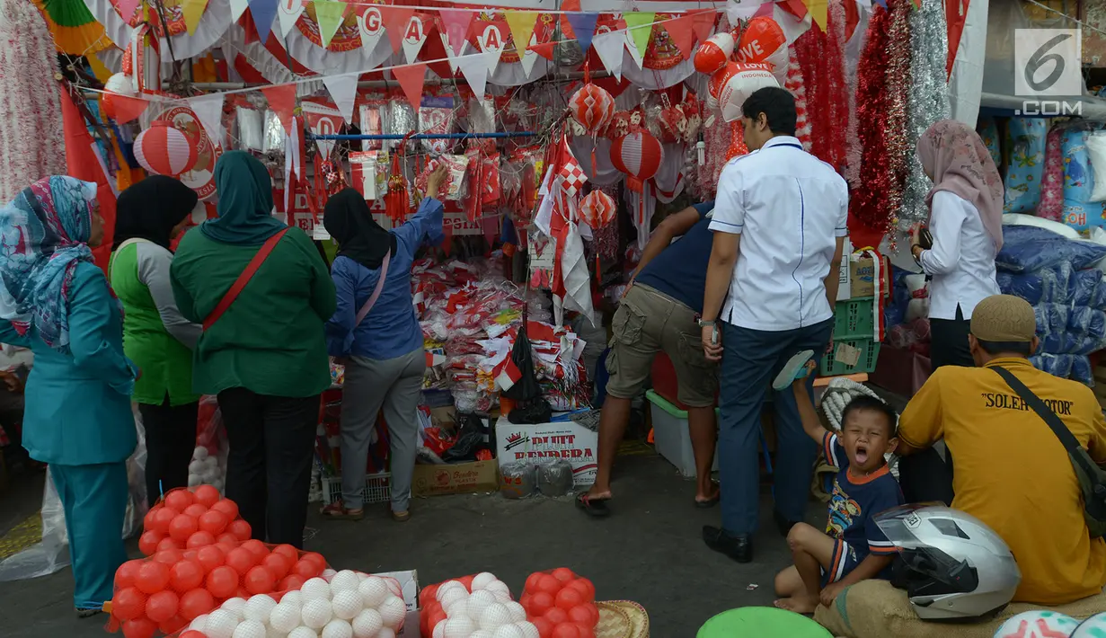 Pembeli melihat-lihat bendera Merah Putih dan pernak-pernik Hari Kemerdekaan di kawasan Pasar Jatinegara, Jakarta, Rabu (14/8/2019). Pedagang musiman memajang beragam jenis aksesoris seperti bendera merah putih, umbul-umbul dan lambang Garuda untuk perayaan HUT ke-74 RI. (merdeka.com/imam buhori)