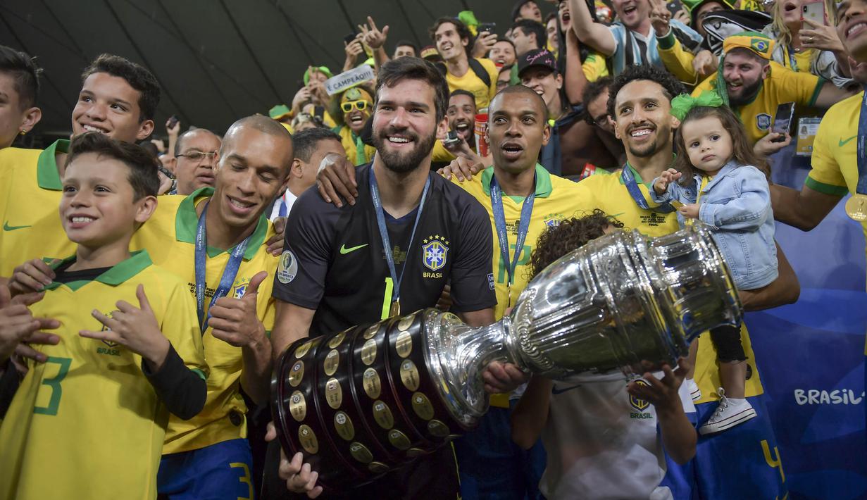 Kiper Brasil, Alisson, bersama rekan-rekannya merayakan gelar juara Copa America 2019 setelah mengalahkan Peru pada laga final di Stadion Maracana, Rio de Janeiro, Minggu (7/7). Brasil menang 3-1 atas Peru. (AFP/Carl De Souza)