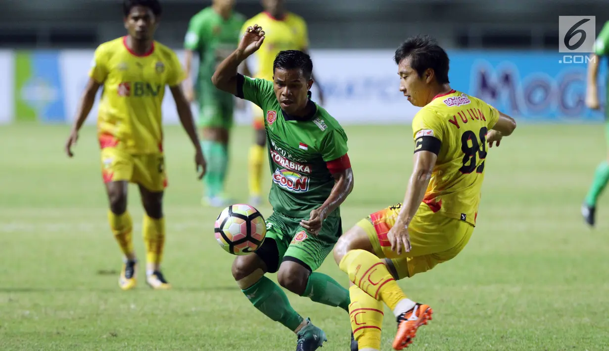 Kapten tim PS TNI, Manahati Lestusen (tengah) berebut bola dengan pemain Bhayangkara FC, Lee Yujun saat lanjutan Liga 1 Indonesia di Stadion Pakansari, Kab Bogor, Minggu (3/9). Bhayangkara FC unggul 1-0. (Liputan6.com/Helmi Fithriansyah)