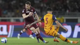 Penyerang Torino, Andrea Belotti berusaha melewati bek AS Roma, Ibanez pada pertandingan lanjutan Liga Serie A Italia di Stadion Olimpiade di Turin, Italia, Sabtu (21/5/2022). Tammy Abraham mencetak dua gol dan mengantar Roma menang telak atas Torino 3-0. (Spada/LaPresse via AP)