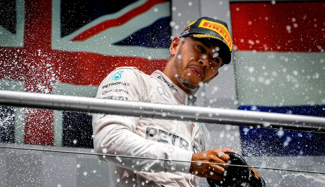 Ekspresi pebalap Mercedes, Lewis Hamilton, di podium juara F1 GP Jerman di Sirkuit Hockenheim, (31/7/2016). Ini adalah kemenangan empat kali beruntun Lewis Hamilton musim ini. (AFP/Sascha Schuermann)
