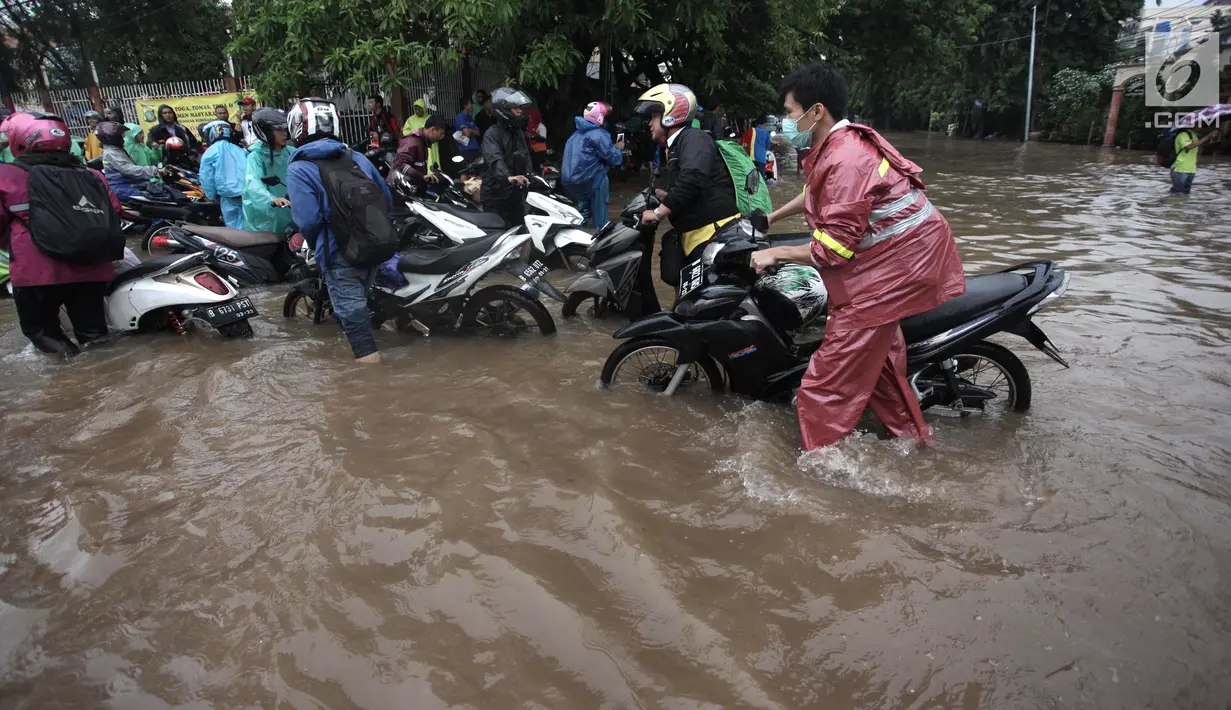 Para pengendara mendorong motornya yang mogok saat melintasi banjir di Jalan Boulevard Barat Raya, Kelapa Gading, Jakarta, Kamis (15/2). Hujan lebat mengguyur Jakarta sejak pagi hingga sore hari. (Liputan6.com/Arya Manggala)