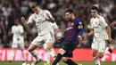 Lionel Messi melakukan operan pendek pada laga semfinal Copa Del Rey yang berlangsung di stadion Santiago Bernabeu, Madrid, Kamis (28/2). Barcelona menang 3-0 atas Real Madrid. (AFP/Oscar Del Pozo)