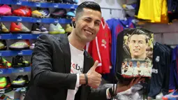 Pemain sepak bola Kurdi Irak, Biwar Abdullah (25) berpose di sebuah toko pakaian olahraga di distrik Soran, timur laut Erbil, 6 April 2019. Biwar Abdullah mendandani dirinya semirip mungkin dengan Cristiano Ronaldo hingga senyum yang nyaris serupa dengan pemain Portugal itu. (REUTERS/Azad Lashkari)