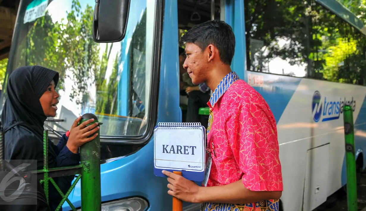 Warga bertanya kepada petugas feeder bus Transjakarta yang sedang ngetem di seberang Stasiun Tebet , Jakarta, Kamis (7/4). Armada itu dikerahkan untuk mengantisipasi penumpukan penumpang saat perlintasan KRL Tebet ditutup. (Liputan6.com/Yoppy Renato)