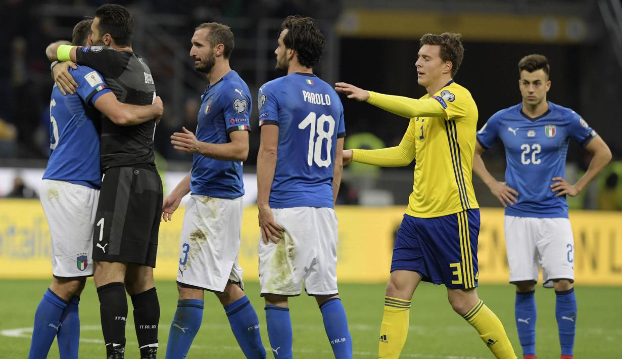 Kapten Italia, Gianluigi Buffon, menenangkan Andrea Barzagli, usai ditahan imbang Swedia pada laga leg kedua playoff Piala Dunia 2018, di Stadion Giuseppe Meazza, Senin (13/11/2017). Italia bermain imbang 0-0 dengan Swedia. (AFP/Miguel Medina)