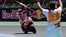 Pembalap Repsol Honda, Marc Marquez membawa bendera saat berselebrasi usai memenangi balapan MotoGP Spanyol 2018 di Sirkuit Jerez, Minggu (6/5). Marquez mengukir waktu 41 menit 39,678 detik. (AFP Photo/ JAVIER SORIANO)