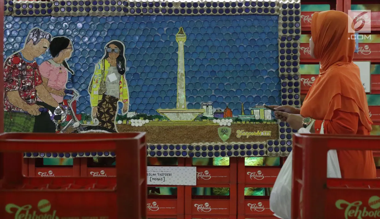 Pengunjung melihat-lihat karya seni instalasi dari bahan bekas pakai yang dipamerkan di terowongan Jalan Kendal-Blora, Jakarta, Selasa (20/8/2019). Rangkaian seni instalasi ini bertema tentang kota Jakarta dan transportasi kereta berlangsung hingga 25 Agustus mendatang. (Liputan6.com/Helmi Fithrians