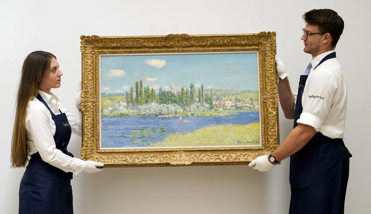 Staf memegang lukisan 'Vétheuil' karya Claude Monet di Sotheby's, London, Inggris, 22 Juni 2022. Lukisan yang akan dilelang pada 29 Juni 2022 itu diperkirakan memiliki harga 10-15 juta pound. (AP Photo /Alberto Pezzali)