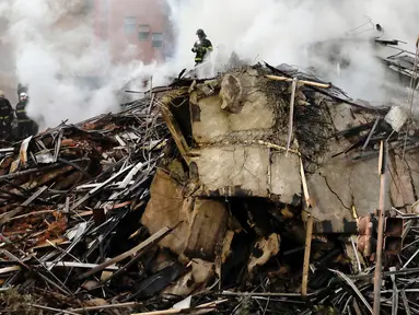 Petugas pemadam kebakaran berada di lokasi sebuah bangunan 26 lantai yang runtuh setelah dilalap api di Sao Paulo, Brasil, Selasa (1/5). Petugas mengatakan baru satu orang yang dipastikan tewasdalam kejadian ini. (AP/Andre Penner)