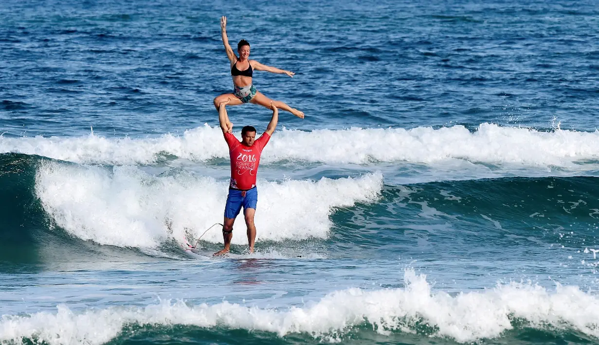 Atlet Prancis, Rico Leroy dan Sarah Burel, beraksi dalam Kejuaraan Internasional Surfing Tandem di Biscarrosse, Prancis, (23/7/2016). (AFP/Mehdi Fedouach)