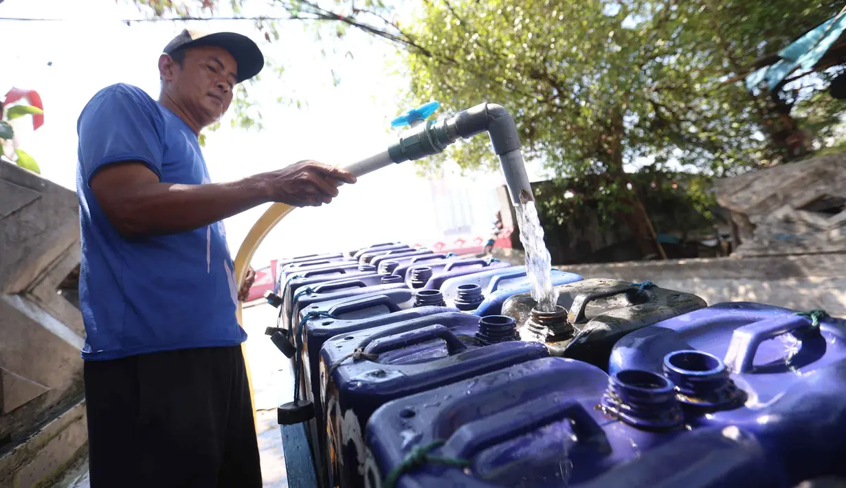 Pedagang mengisi jeriken dengan air bersih untuk segera didistribusikan kepada pelanggan di Kawasan Muara Angke, Jakarta, Kamis (28/5/2026). (Kapanlagi.com/Budy Santoso)