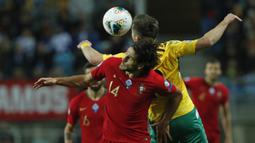 Penyerang Portugal, Goncalo Paciencia berebut bola udara dengan pemain Lithuania, Saulius Mikoliunas pada pertandingan Grup B Kualifikasi Piala Eropa 2020 di stadion Algarve di luar Faro, Portugal (14/11/2019). Portugal menang besar 6-0 atas Lithuania. (AP Photo/Armando Franca)